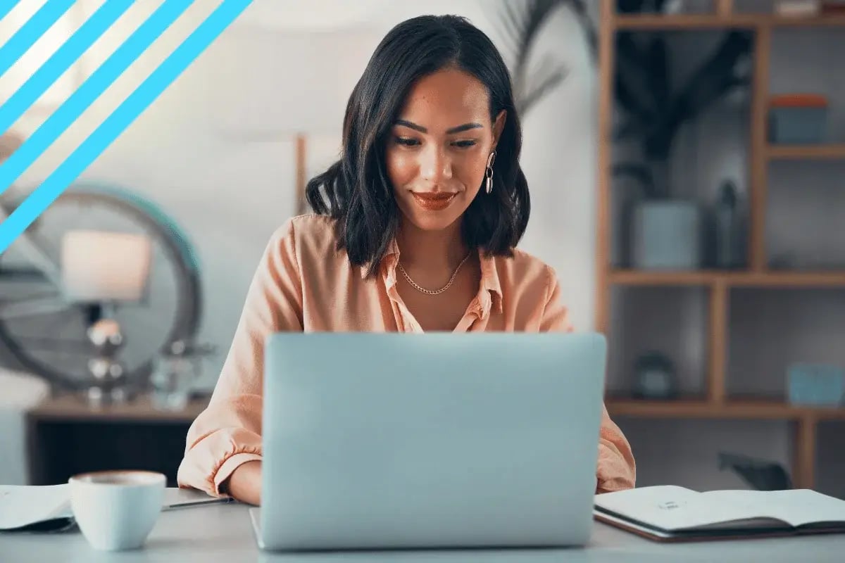 Focused woman working on a laptop in a cozy home office with shelves and bicycle in the background.