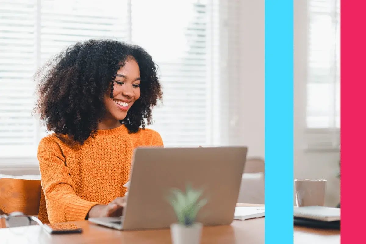 A woman in an orange sweater smiles at a laptop in a bright room. A small plant and notebooks sit on the table. Vertical blue and pink bars border the image.